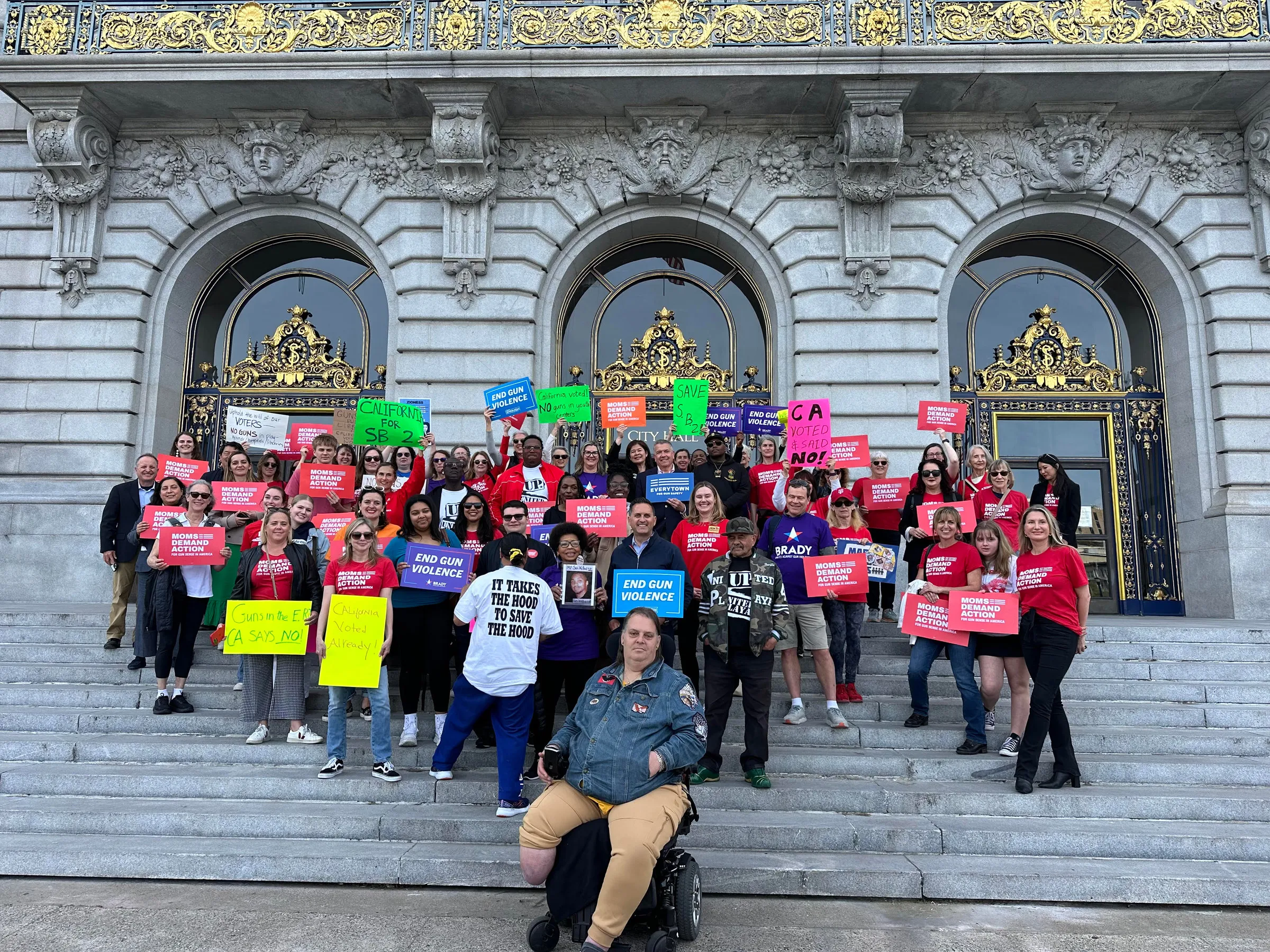 Students and community members holding signs on the steps of San Francisco City Hall