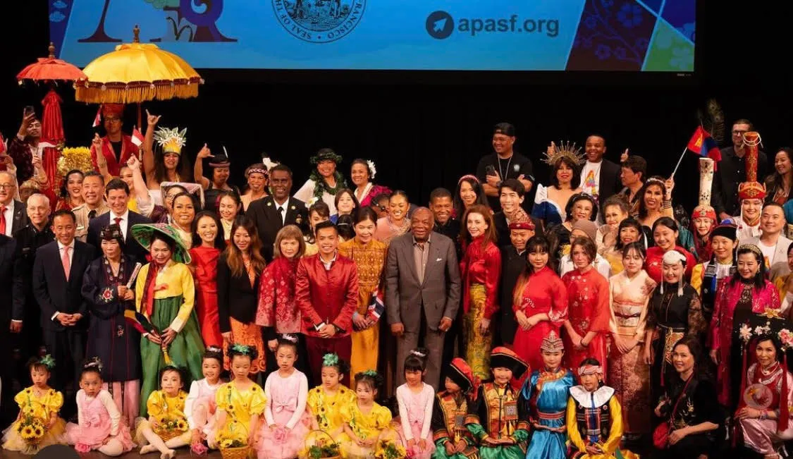Performers and families on stage at a community cultural celebration