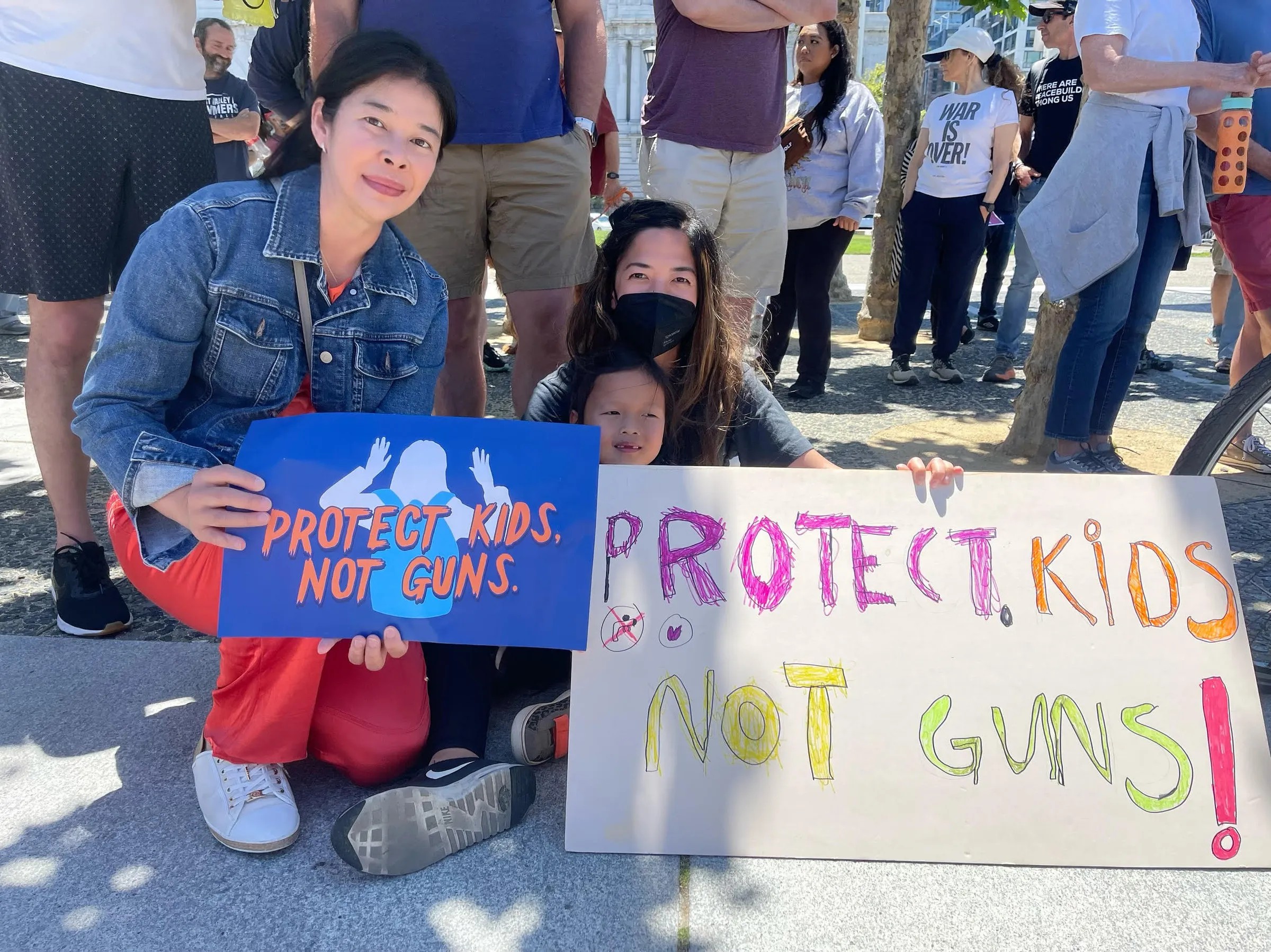 Monthanus Ratanapakdee with families holding Protect Kids Not Guns signs